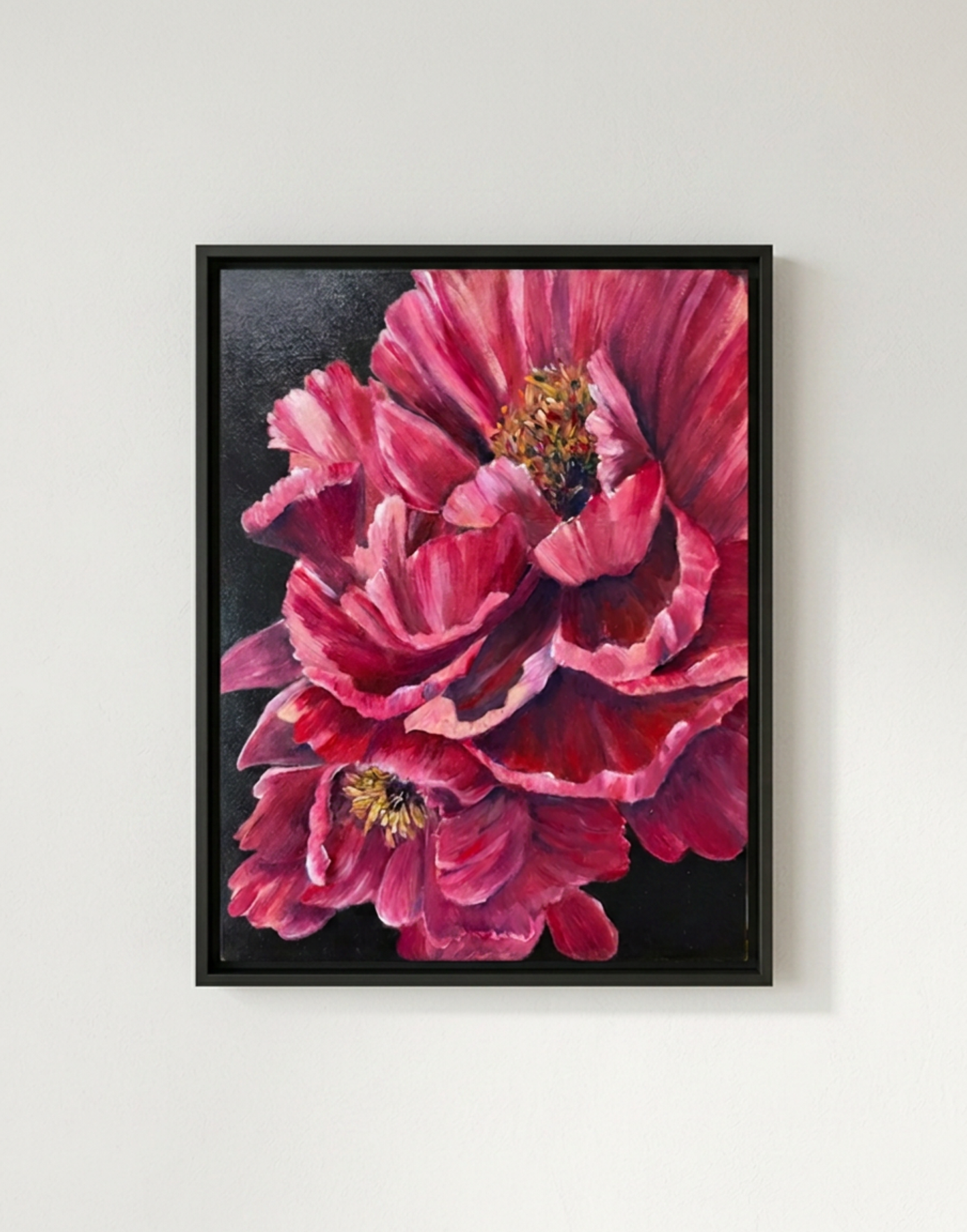 Framed artwork of a pink flower on a white wall